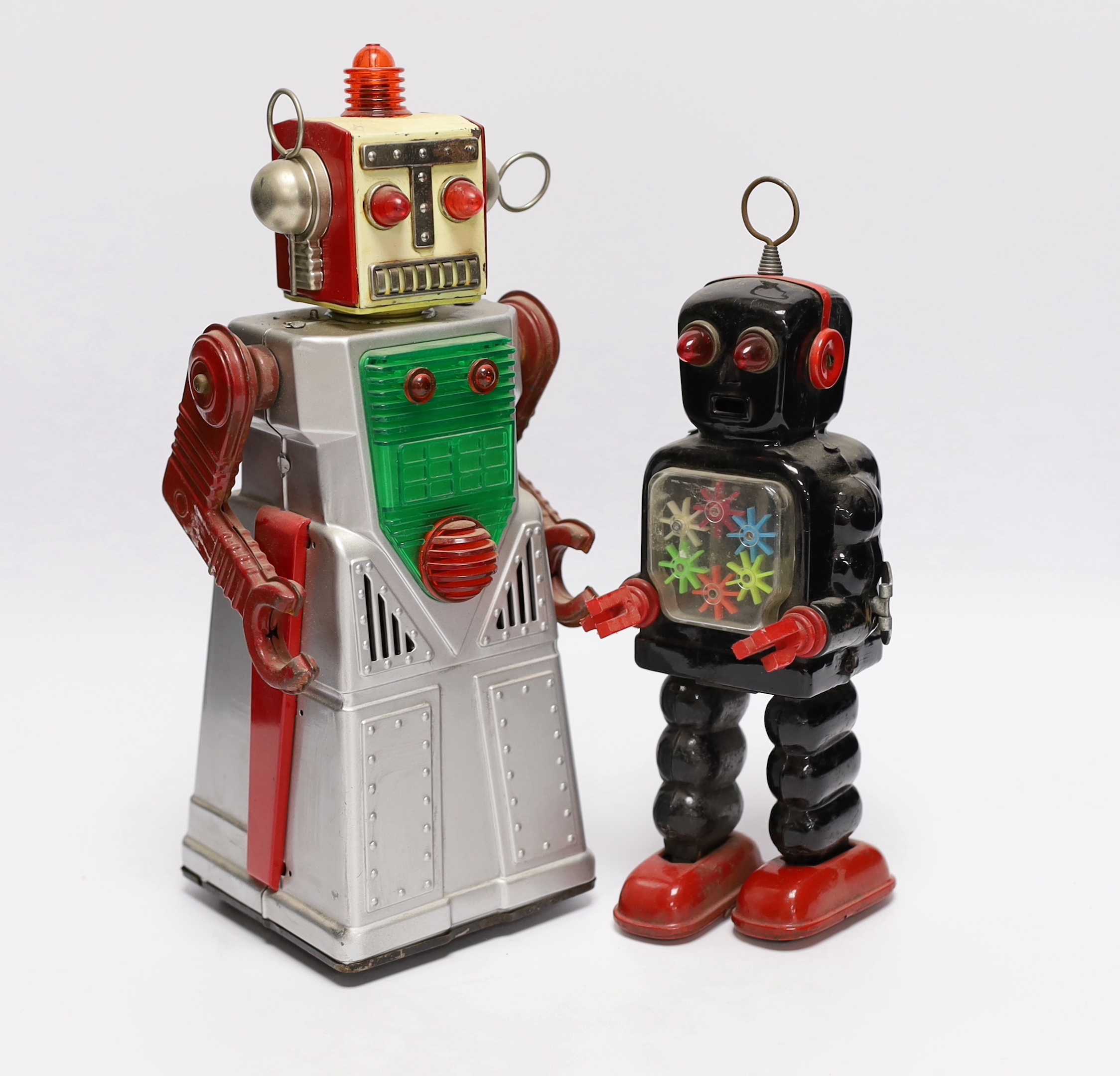 Four 1960s Japanese battery and clockwork powered robots, including; a boxed Horikawa (SH Toys) Fighting Robot, another smaller example by Horikawa, a Yoshiya (KO) silver robot and a Yoshhiya black clockwork robot, talle